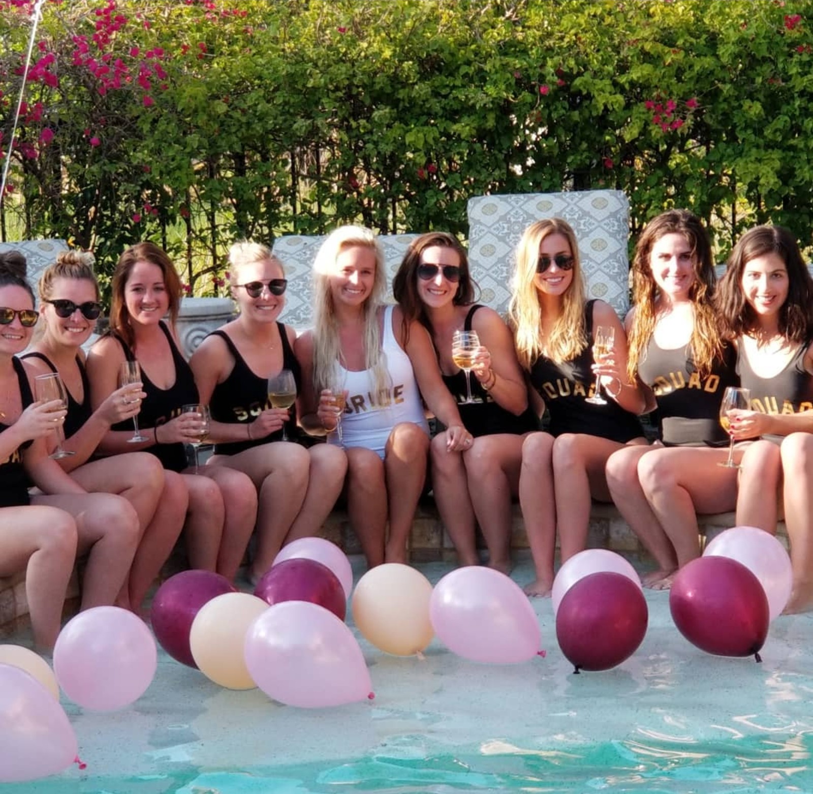 Bride and squad sitting on the pool ledge