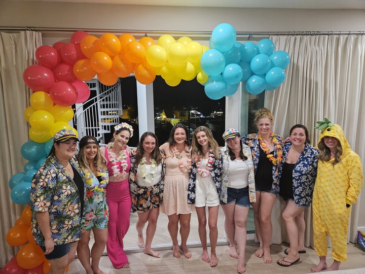 Party guests under a balloon arch