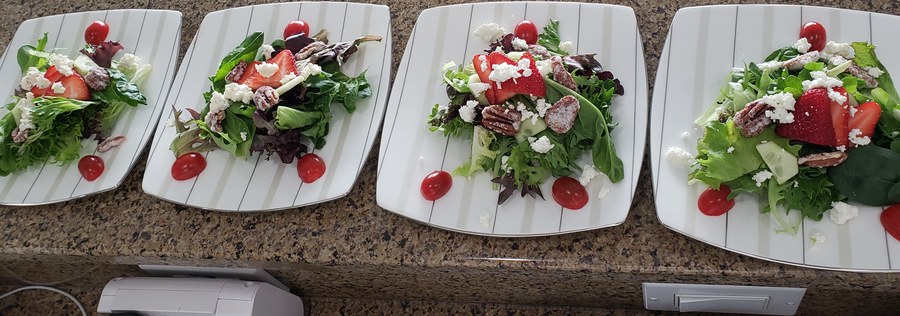 Plated salads lined up on the counter